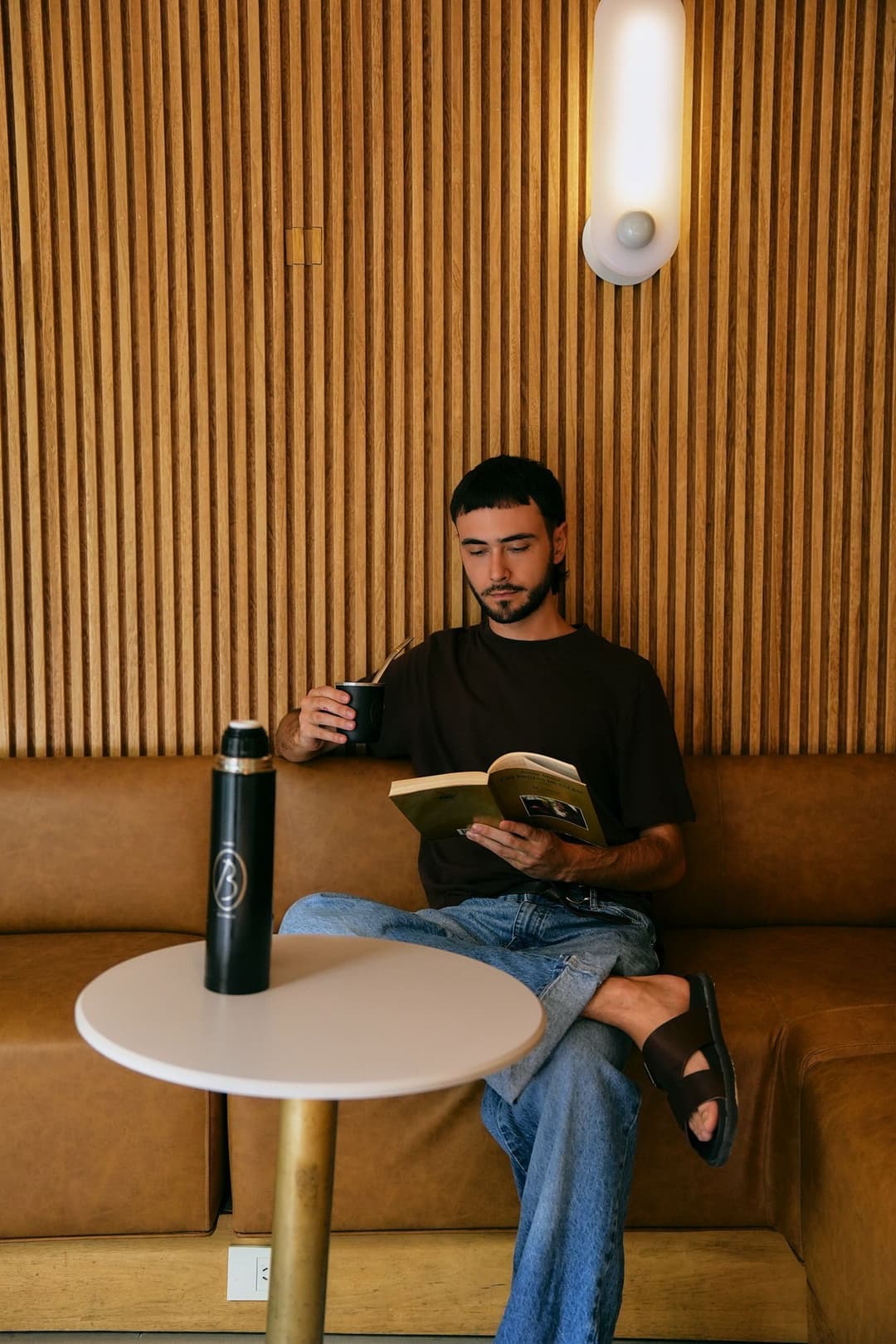 Chico sentado con mate y un libro